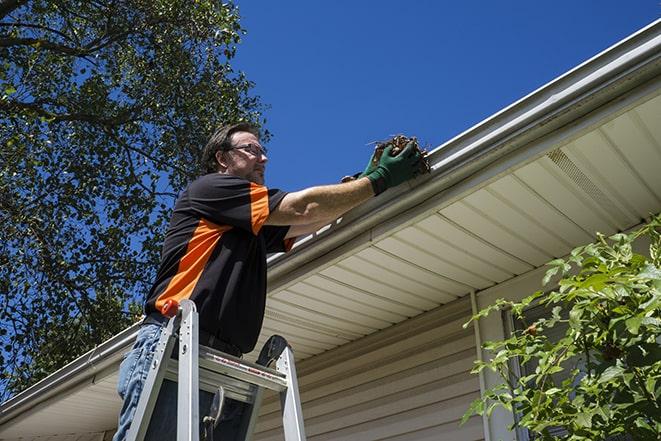 home renovation worker replacing broken gutter sections in Montclair CA